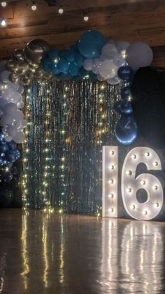 the number sixteen is displayed in front of balloons and streamers on the dance floor