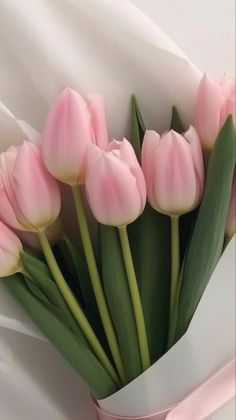 a bouquet of pink tulips wrapped in white paper