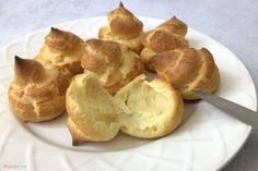 a white plate topped with rolls on top of a table next to a knife and fork