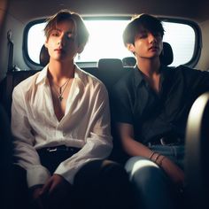 two young men sitting in the back of a car