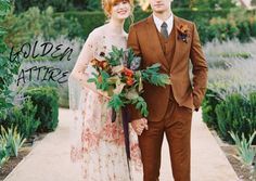 a man and woman standing next to each other in front of bushes with flowers on them