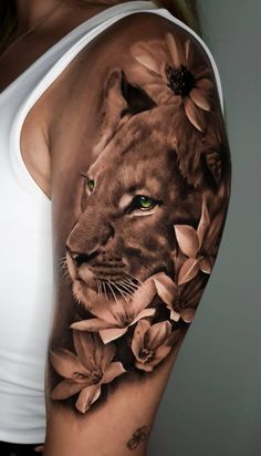 a woman's arm with a lion and flowers tattoo on the left side of her body