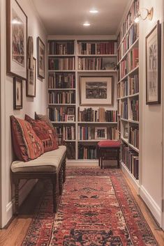 a hallway with bookshelves and rugs on the floor