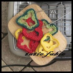 some crocheted items are sitting on a cutting board next to an oven door