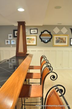 an empty bar with wooden chairs and pictures on the wall