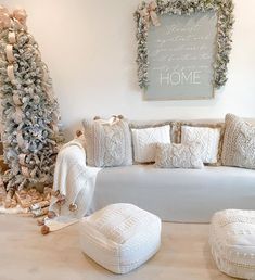 a living room filled with white furniture and christmas decorations