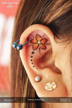 an ear with a flower tattoo on it