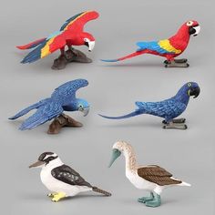 six different types of toy birds sitting on top of each other's legs and feet