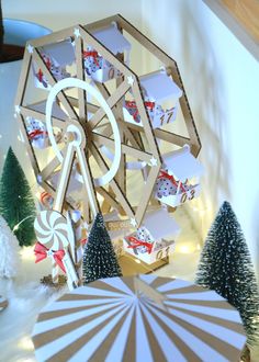 a ferris wheel surrounded by christmas trees and other holiday decorations on the wall behind it