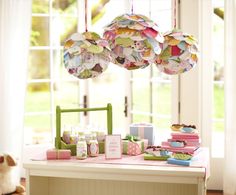 a table with paper decorations hanging from it's ceiling and other items on the table