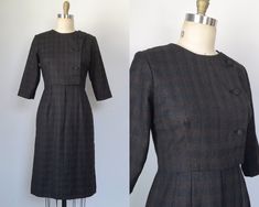 "This handsome wool dress has three fabric-covered buttons on a left-offset panel for a mod look. The fabric is a deep graphite color that is mottled with light blue, ivory, and reddish-brown to create an understated plaid. Crew neckline and three-quarter-length sleeves. Subtle pleats at the waist seam. Fully lined.  Superb vintage condition. No holes, stains, or other significant damage that we could spot.  No brand or fiber content information. Fabric is definitely wool, most likely 100%, but a high-wool blend is possible.  No marked size, so please see the following measurements to ensure an accurate fit.  Bust: 36\" Waist: 31\" Hip: 39\" Sleeve: 15.5\" Shoulder: 14.5\" Length: 40\"" Mod Look, Fabric Covered Button, Brown Plaid, Reddish Brown, Wool Dress, Blue Ivory, Vintage 1960s, Covered Buttons, Fabric Covered