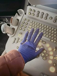 a gloved hand is on top of a computer keyboard