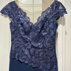 a blue dress with flowers on the shoulders