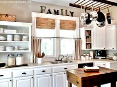 a kitchen filled with lots of white cabinets and counter top space next to a window