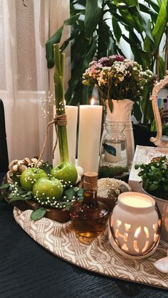 a table topped with lots of different types of flowers and candles on top of it