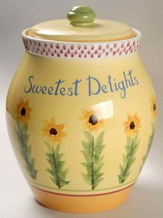 a ceramic jar with sunflowers painted on it's sides and the words sweetest delights written in blue