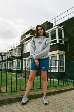 a woman standing on a sidewalk in front of a building Casual Sports Hoodie Relaxed Fit, Casual Sports Hoodie With Relaxed Fit, Spring Sports Hoodie With Relaxed Fit, Casual Sports Sweatshirt With Embroidered Logo, Sporty Relaxed Fit Hoodie For Spring, Sporty Relaxed Fit Spring Hoodie, Casual Sports Hoodie With Embroidered Logo, Sporty Spring Hoodie With Relaxed Fit, Spring Sporty Hoodie In Relaxed Fit