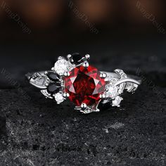 a red stone surrounded by white diamonds on top of a rock