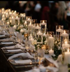 a long table is set with candles and place settings for dinner guests to sit at