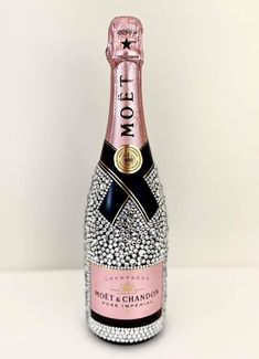 a bottle of champagne that has been decorated with diamonds and stars on the label is sitting on a white surface