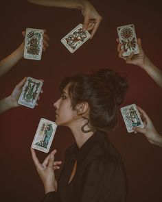 a woman surrounded by playing cards in her hands