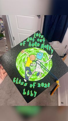 a person holding a graduation cap with the words happy birthday written in green on it