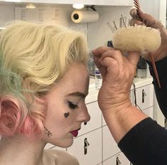 a woman is getting her hair done in the kitchen