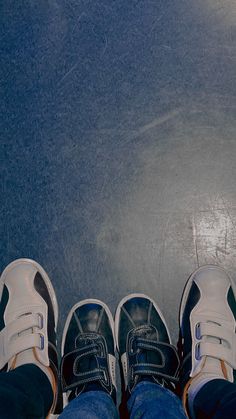 two people standing next to each other with their feet up on the ground and wearing tennis shoes