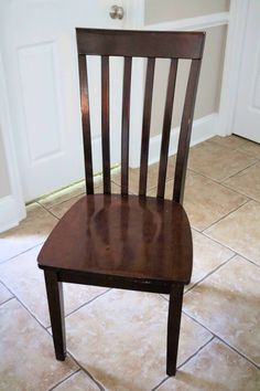 a wooden chair sitting on top of a tile floor