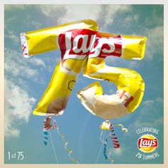 an image of balloons with the number five on them flying in the blue sky and clouds