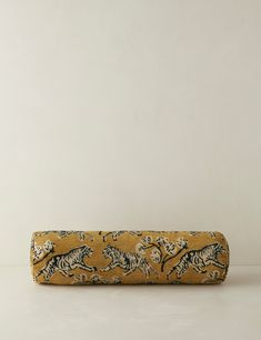 a long yellow and black case with tiger designs on the front, sitting against a white wall