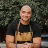 a man in an apron is smiling for the camera