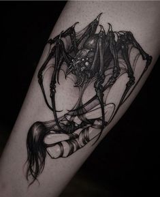 a black and white photo of a woman with a spider tattoo on her leg,