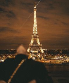 the eiffel tower is lit up at night with lights on it's sides