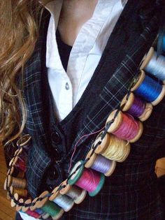 a woman wearing a vest with many spools of thread