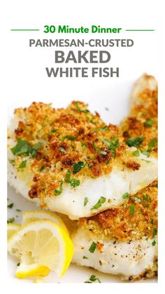 some fish on a plate with lemon wedges and parmesan crusted bread