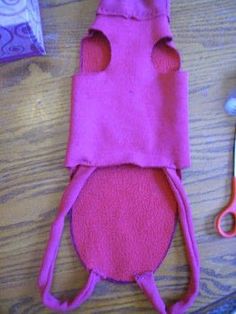 a pair of scissors and pink material sitting on top of a wooden table next to other items