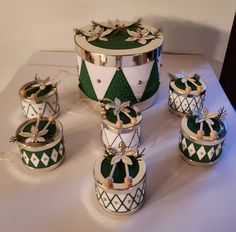 an assortment of green and white christmas ornaments on a table with silver trimmings