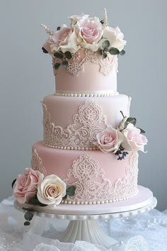 a three tiered cake with pink frosting and flowers