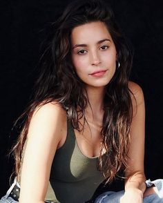 a beautiful young woman sitting on top of a pair of jeans