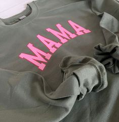 "Shirts are unisex. Refer to pics for sizing help. Shirt is a military green with pink and red varsity MAMA graphic graphic is vinyl Caring for Instructions: Turn garment inside-out. Cold wash temp with mild detergent. Tumble dry low. Sweatshirt info: Pick true size if you want a slightly oversized fit. Size down for smaller,  tighter fit. 50% cotton 50% polyester Approx. Length: S- 25.5\" M-27\" L-27.5\" XL- 28\" *Please keep in mind that actual color may vary slightly from photos due to lighti Mama Shirts, Mama Shirt, Military Green, Mom Shirts, Mom Life, Crew Neck Sweatshirt, Gender Neutral, Crew Neck, Turn Ons