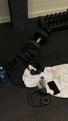 the gym equipment is laying on the floor next to the water bottle and other items