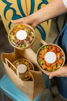 two people are holding bowls with food in them