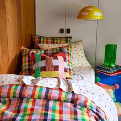 a bed with colorful plaid sheets and pillows