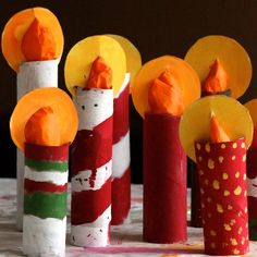 there are many different colored candles made out of toilet paper and strawberries on the table