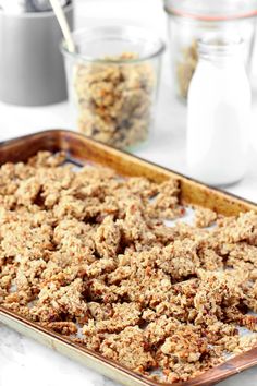 a baking pan filled with oatmeal crumbs next to other ingredients