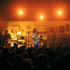 a group of people that are standing in front of a microphone and some guitar players