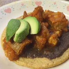 a close up of a plate of food with meat and avocado on it