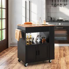 a kitchen island cart with wine bottles on it in front of an oven and stove