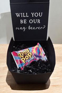 a black box with a candy bar inside it that says will you be our ring bearer?